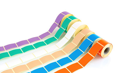 Five rolls of different colored label paper on white background